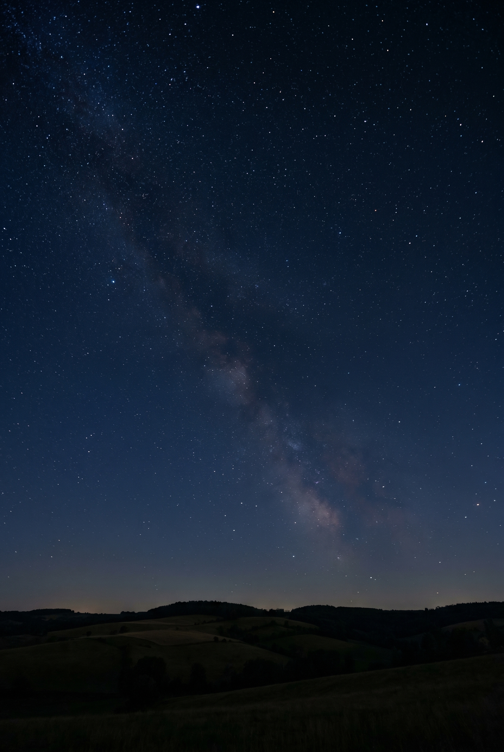 Photographie circumpolaire montrant la constellation de la Grande Ourse avec un léger filé d'étoiles au-dessus de collines