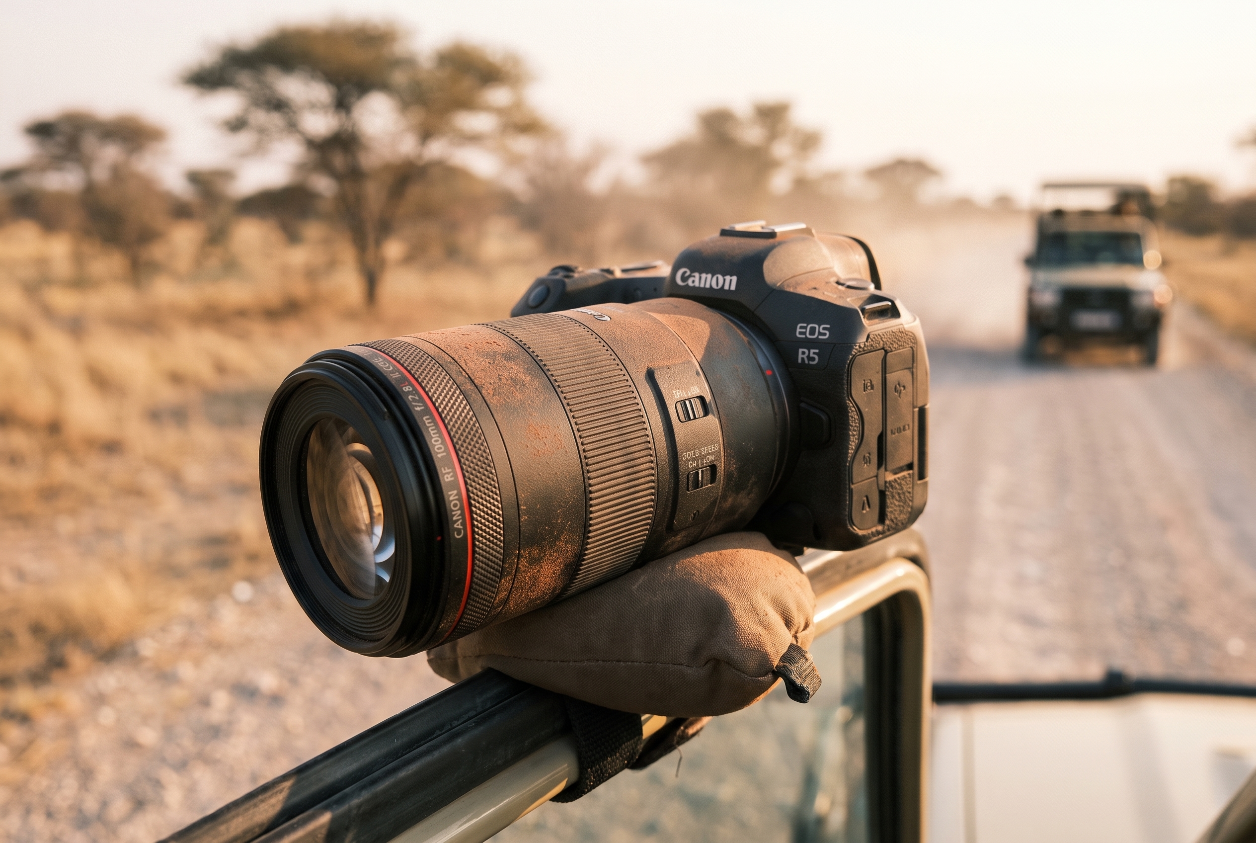 Réussir son safari photo : le bon matériel et les erreurs à éviter 18 Appareil photo hybride avec téléobjectif couvert de poussière rouge sur un support de portière lors d'un safari photo à Etosha.