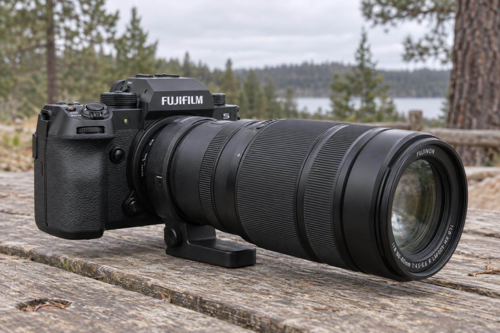 Boîtier Fujifilm X-H2S avec téléobjectif Fujinon posé sur une table en bois lors d'un test de photo animalière en extérieur.